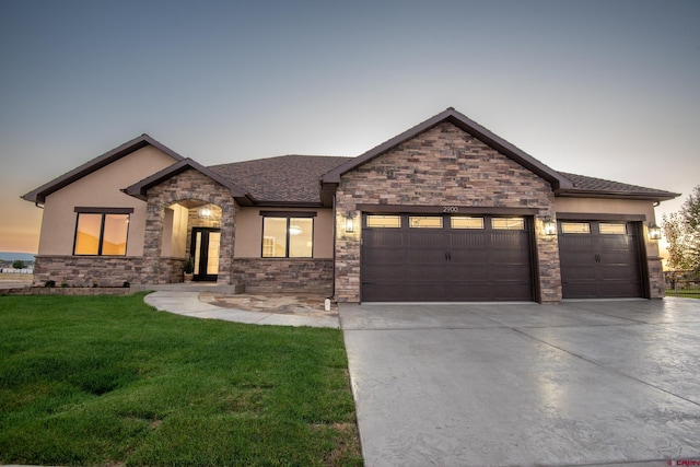 view of front of home with a garage and a yard