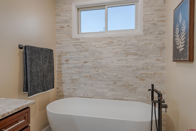 bathroom with a tub and vanity