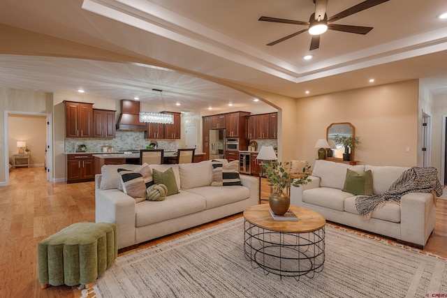 living room featuring ceiling fan and light hardwood / wood-style floors