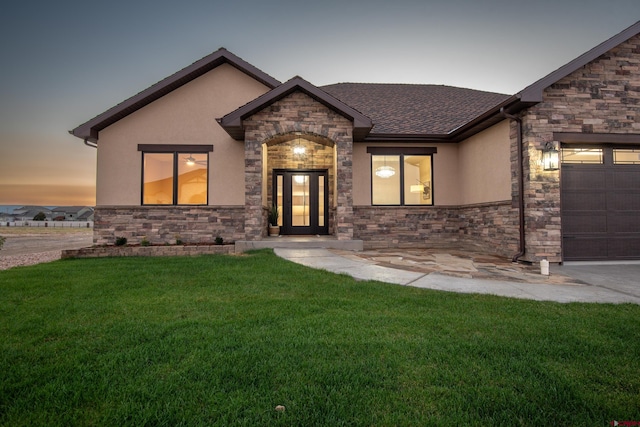 view of front of home featuring a garage and a yard