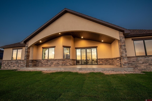 rear view of property featuring a patio area and a lawn