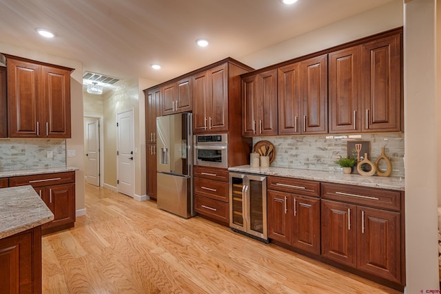 kitchen featuring tasteful backsplash, beverage cooler, stainless steel appliances, and light hardwood / wood-style floors