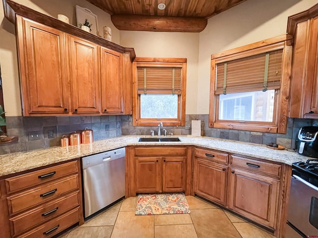 kitchen featuring beam ceiling, sink, stainless steel appliances, and plenty of natural light