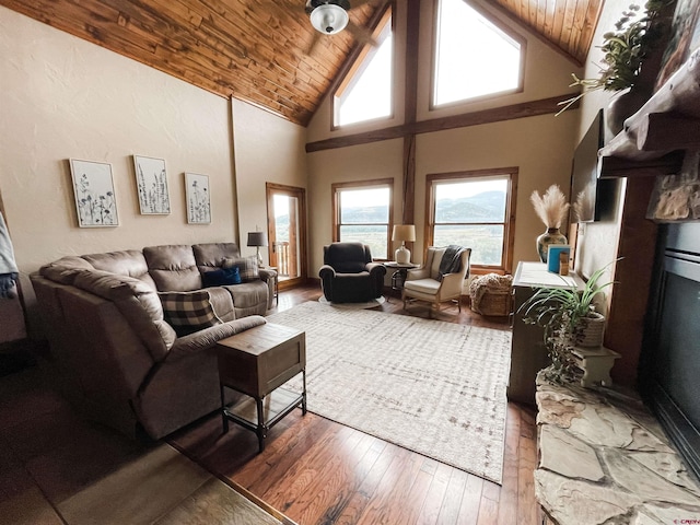 living room featuring wooden ceiling, dark hardwood / wood-style floors, high vaulted ceiling, and a stone fireplace