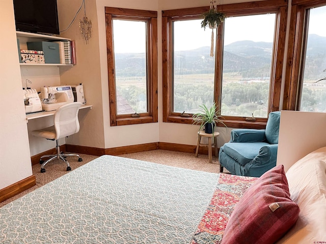 carpeted office space featuring a mountain view and built in desk