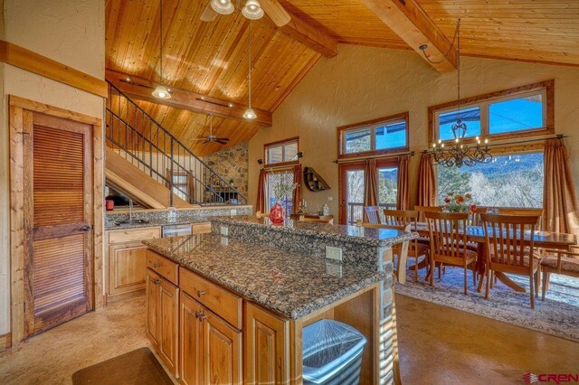 kitchen featuring wooden ceiling, high vaulted ceiling, a kitchen island, dark stone countertops, and beam ceiling