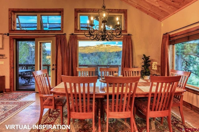 dining area with a chandelier, a healthy amount of sunlight, concrete flooring, and vaulted ceiling