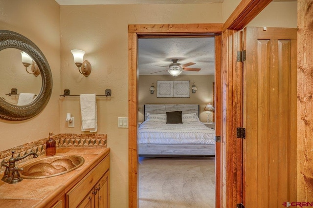 bathroom featuring ceiling fan, vanity, and a textured ceiling