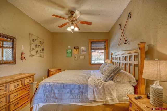 bedroom with ceiling fan and a textured ceiling