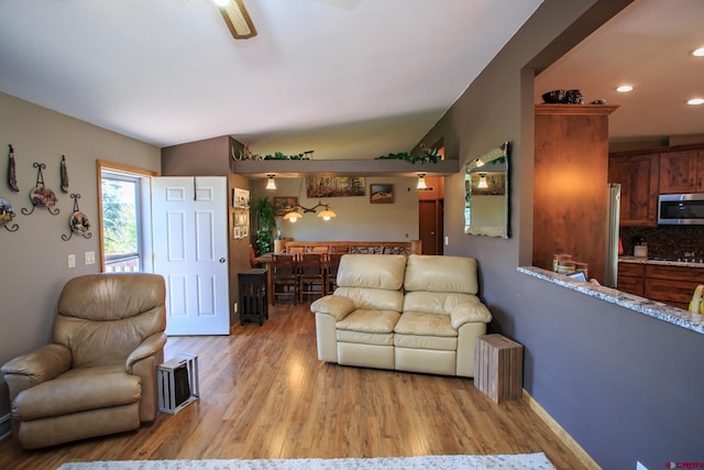 living room with light hardwood / wood-style floors and vaulted ceiling