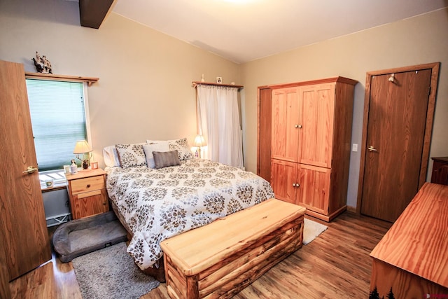 bedroom with hardwood / wood-style floors and lofted ceiling