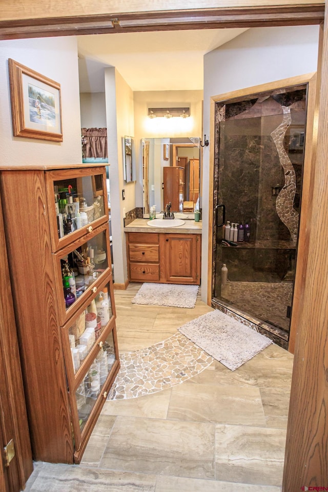 bathroom with a shower with door and vanity