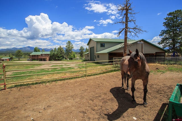 view of stable featuring a mountain view and a rural view