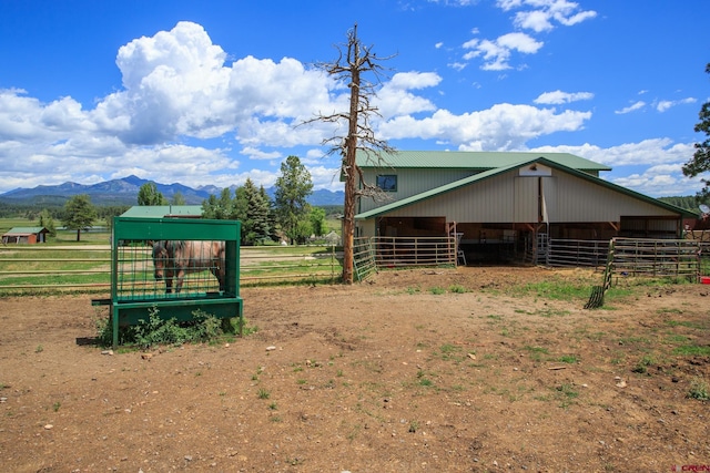 view of stable featuring a mountain view and a rural view