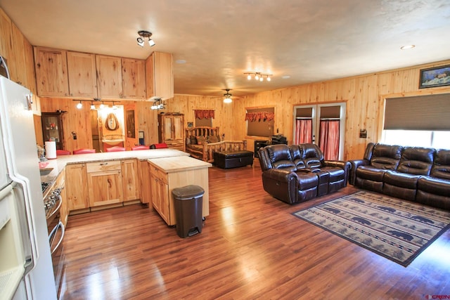 kitchen featuring kitchen peninsula, ceiling fan, light brown cabinets, and wood-type flooring