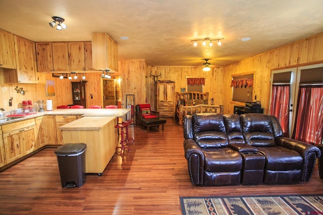 kitchen with wooden walls, ceiling fan, light brown cabinetry, butcher block countertops, and wood-type flooring