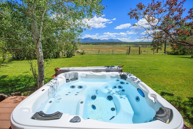 view of yard featuring a mountain view, a rural view, and a hot tub