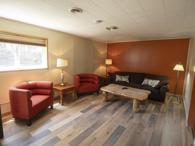 living room with wood walls and wood-type flooring