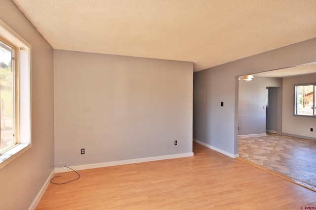 empty room featuring light wood-type flooring and a textured ceiling