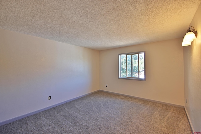 carpeted empty room with a textured ceiling