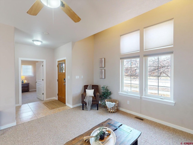 sitting room with ceiling fan and light colored carpet