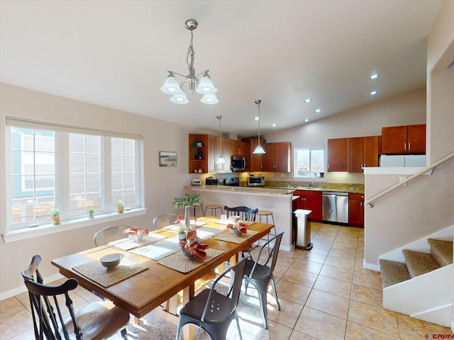 dining area featuring sink, light tile patterned floors, lofted ceiling, and an inviting chandelier