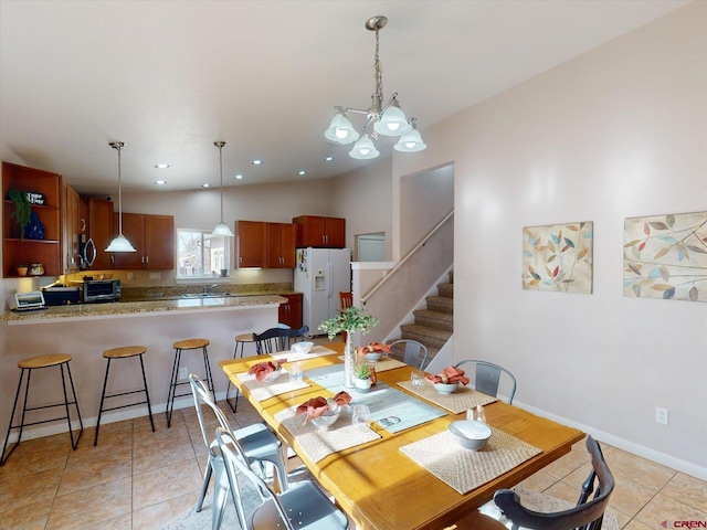 tiled dining area featuring sink and a chandelier