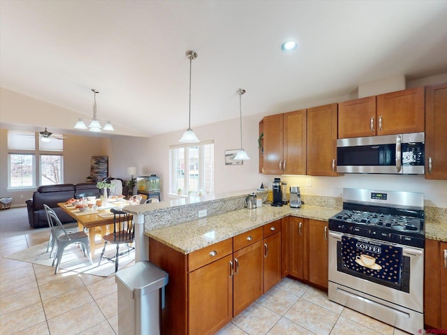 kitchen with lofted ceiling, kitchen peninsula, stainless steel appliances, and a wealth of natural light