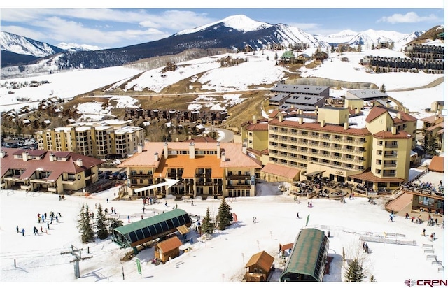 snowy aerial view featuring a mountain view