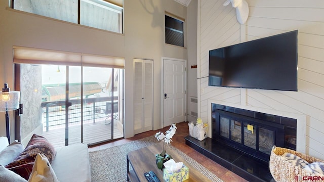 living room with hardwood / wood-style flooring, wood walls, and a high ceiling