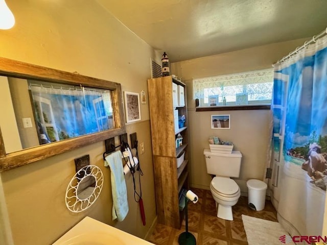 bathroom featuring a shower with shower curtain and toilet