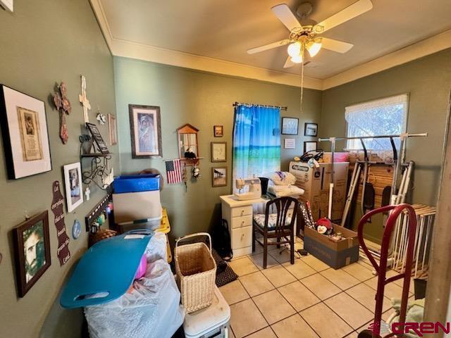 interior space with ceiling fan and crown molding