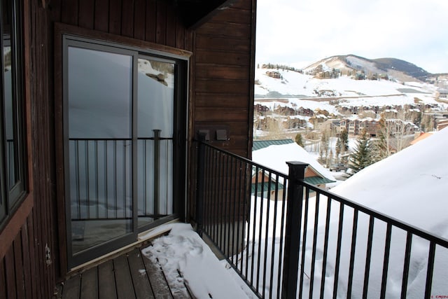 snow covered back of property with a mountain view