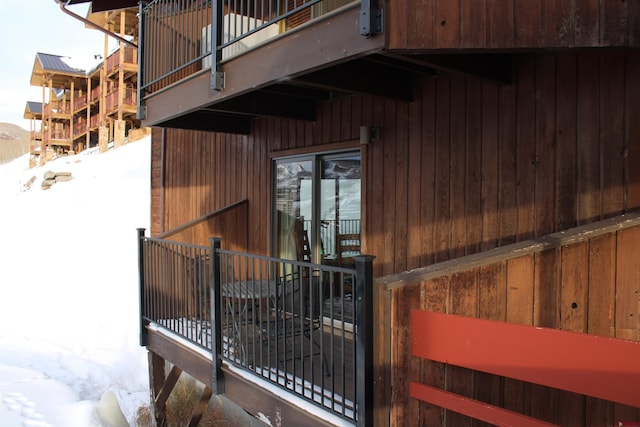 snow covered property with a balcony