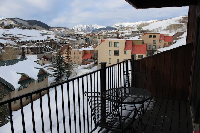 snow covered back of property featuring a mountain view