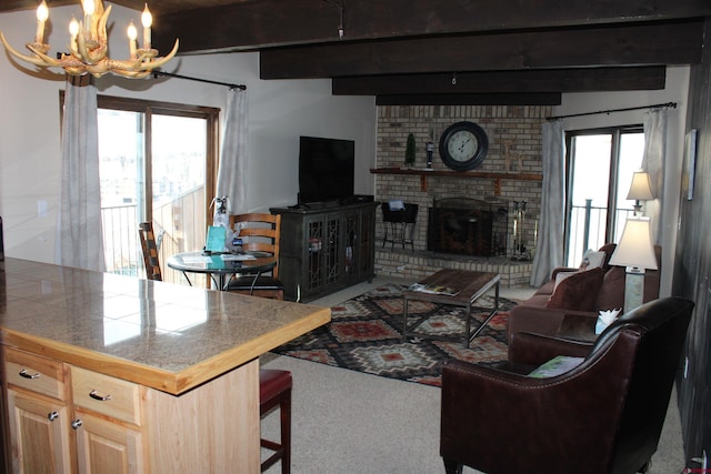 living room with carpet, beam ceiling, a fireplace, and a healthy amount of sunlight