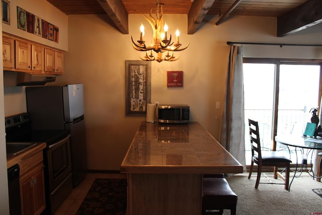 kitchen featuring black appliances, hanging light fixtures, beam ceiling, wood ceiling, and a breakfast bar area