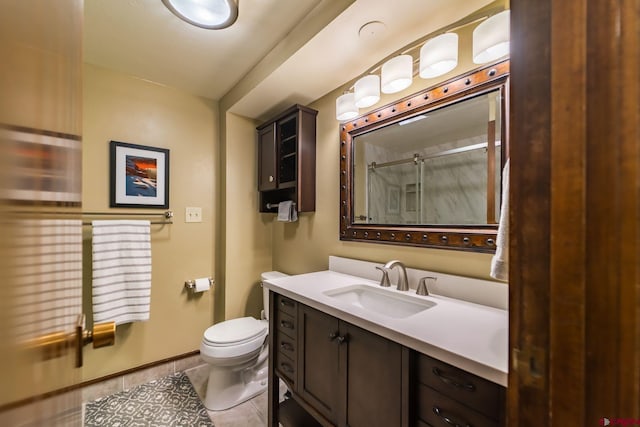 bathroom with tile patterned flooring, vanity, a shower with shower door, and toilet