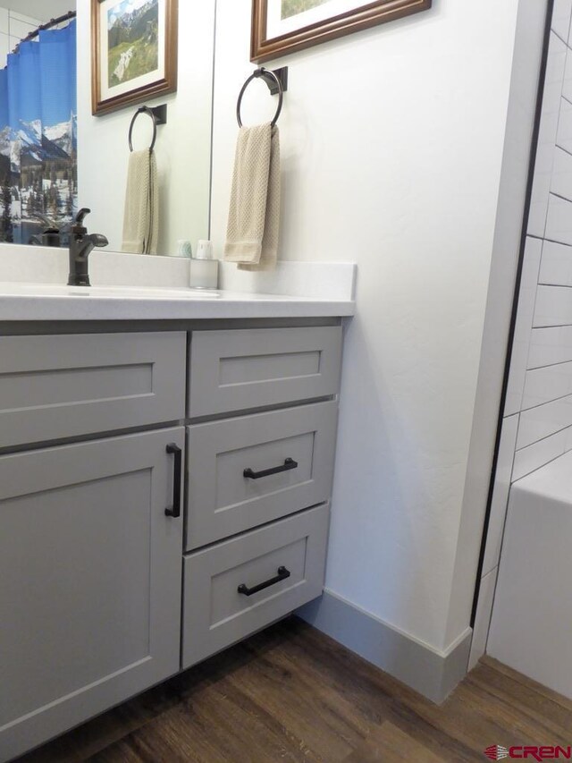 bathroom featuring shower / tub combo with curtain, vanity, and hardwood / wood-style flooring