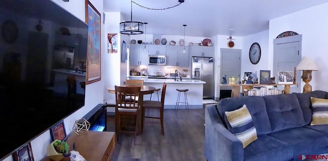 living room featuring dark hardwood / wood-style floors, an inviting chandelier, and sink