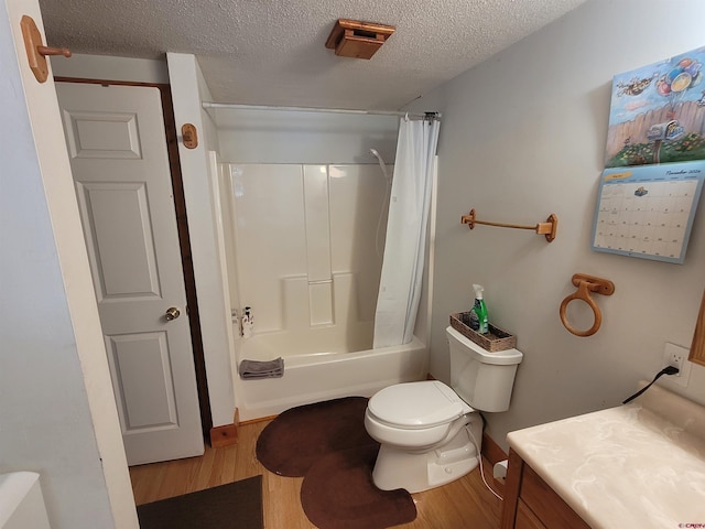 full bathroom featuring hardwood / wood-style floors, vanity, toilet, a textured ceiling, and shower / tub combo