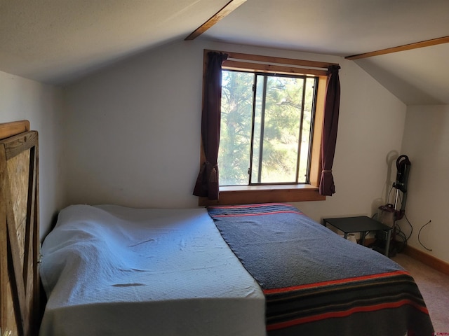 bedroom with vaulted ceiling with beams, carpet floors, and multiple windows