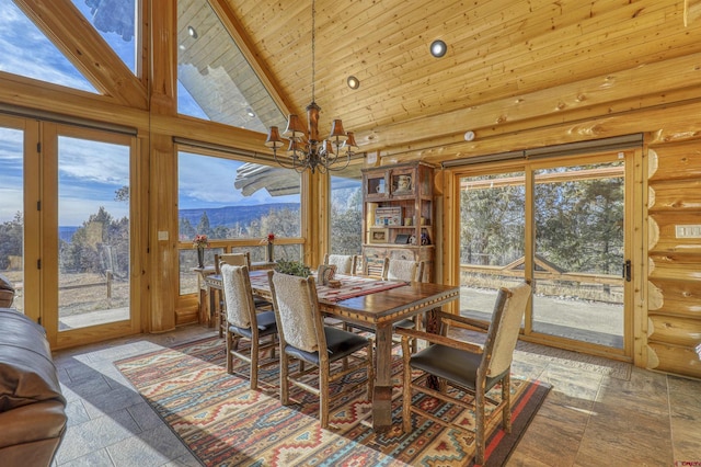 dining area with rustic walls, wood ceiling, an inviting chandelier, high vaulted ceiling, and a mountain view