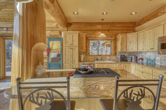 kitchen featuring light stone countertops, light brown cabinetry, and rustic walls