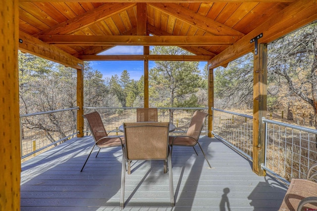 sunroom / solarium featuring lofted ceiling with beams and wooden ceiling