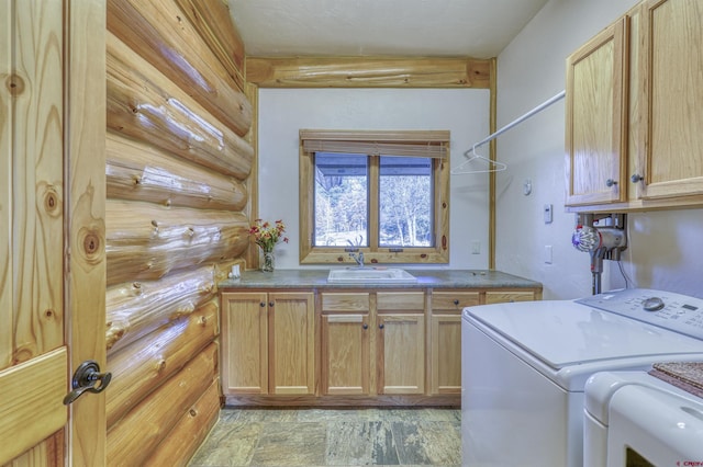 laundry area with separate washer and dryer, sink, and cabinets