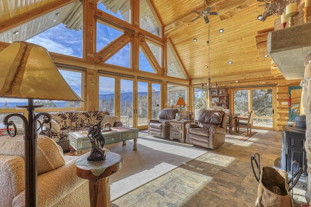 living room featuring a mountain view, high vaulted ceiling, wooden ceiling, and ceiling fan with notable chandelier