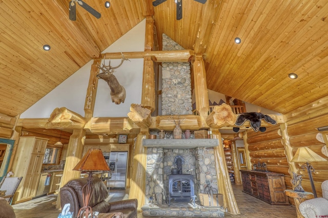 living room with a wood stove, high vaulted ceiling, ceiling fan, rustic walls, and wood ceiling