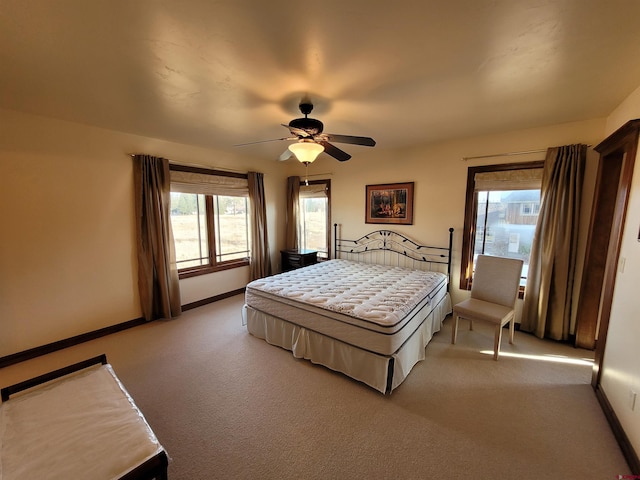 bedroom with ceiling fan, light carpet, and multiple windows