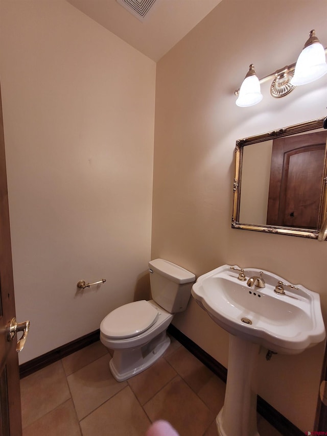 bathroom with toilet and tile patterned flooring